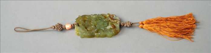 A Chinese carved and pierced green and russet jade pendant 6 cms long. Generally in good