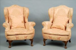 A pair of 18th century style upholstered wing back armchairs The padded back above scrolling arms