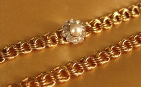 An unmarked yellow metal diamond and pearl necklet Centred with a central split pearl with a diamond