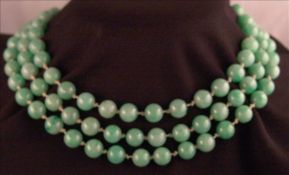 A jade bead necklace Housed in a tooled leather case inscribed Hemming & Co., 28 Conduit Street,