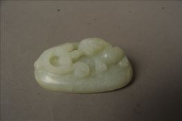A Chinese jade buckle The domed body carved with a dog-of-fo. 8 cms wide. Overall good, some