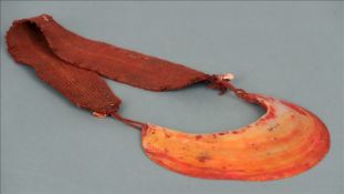 A South Seas, possibly Papua New Guinea neck dress Formed from an oyster shell with red painted