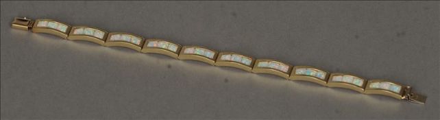 A 14 ct gold opal bracelet Each link set with three opals. 20 cms wide. Generally in good condition,