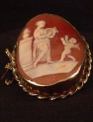 An unmarked yellow metal mounted cameo brooch Carved with Aphrodite playing her lyre and with a
