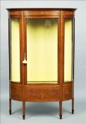 An Edwardian inlaid mahogany bow fronted display cabinet The moulded top above panels of scrolling