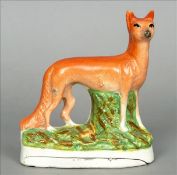 A 19th century Staffordshire pottery figure of a fox Modelled standing, on a naturalistic base. 16.5