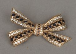 A 9 ct gold diamond and sapphire brooch Formed as a tied bow. 4 cms wide. Generally good, some