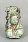 A Chinese carved pale and russet jade pendant Modelled as a seated sage. 5 cms high. Generally in