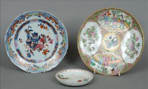 A 19th century Cantonese famille rose plate Decorated with vignettes with figures in interiors and