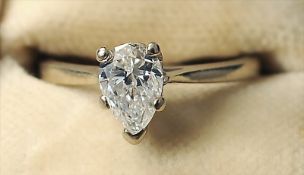 A 14 ct white gold diamond solitaire ring The claw set pear shaped stone spreading to