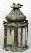 An early 19th century patinated bronze lantern The shaped domed top surmounted with a loop handle,