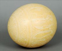 A late 19th century carved ostrich egg The body carved with bands of scrolling decoration with