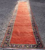 A Kazak wool runner The wine red field within a stylised herati border. 448 x 87 cms. Generally in