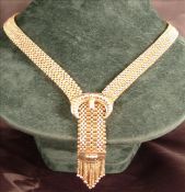 A 20th century 14 ct gold necklace Centred with a bead decorated buckle above a tassel mounted drop.