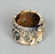 A Chinese carved white and black jade archers ring Of circular section with incised decoration;