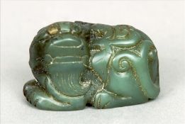 A Chinese carved jade model of a dog-of-fo Of typical crouching form. 5.25 cms wide. Some slight