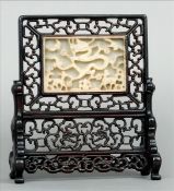 A Chinese mutton fat jade and carved hardwood table screen The pierced and carved hardwood panel