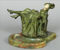 An Art Deco ivory and painted bronze figurine Modelled draped across a chair smoking, her hinged