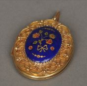 A 9 ct gold enamel decorated locket The hinged case decorated with pierced scrollwork bordering a