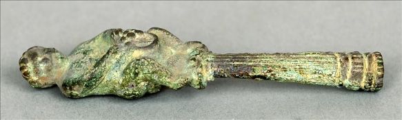 A cast metal pipe tamper The handle formed as a bacchic figure above the reeded tamper with