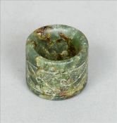 A Chinese carved green jade archers ring Of circular section with incised scrolling decoration;