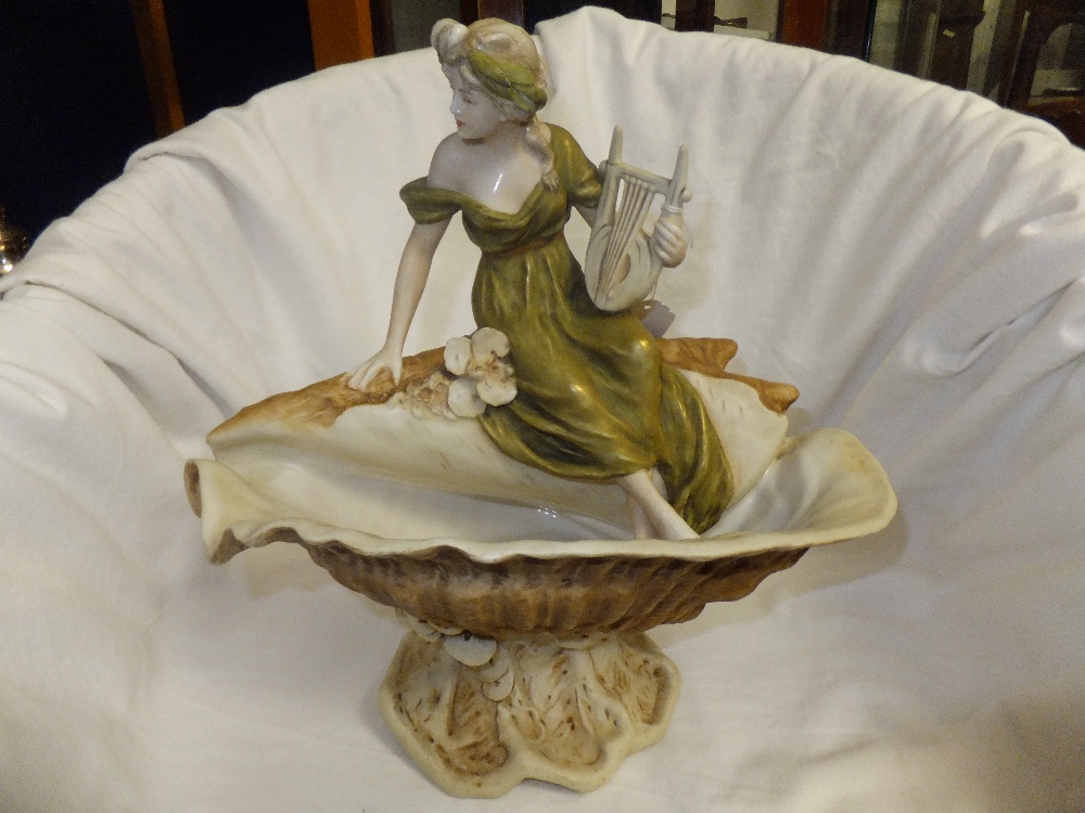 A Royal Dux table centre piece depicting a female musician astride a sea shell