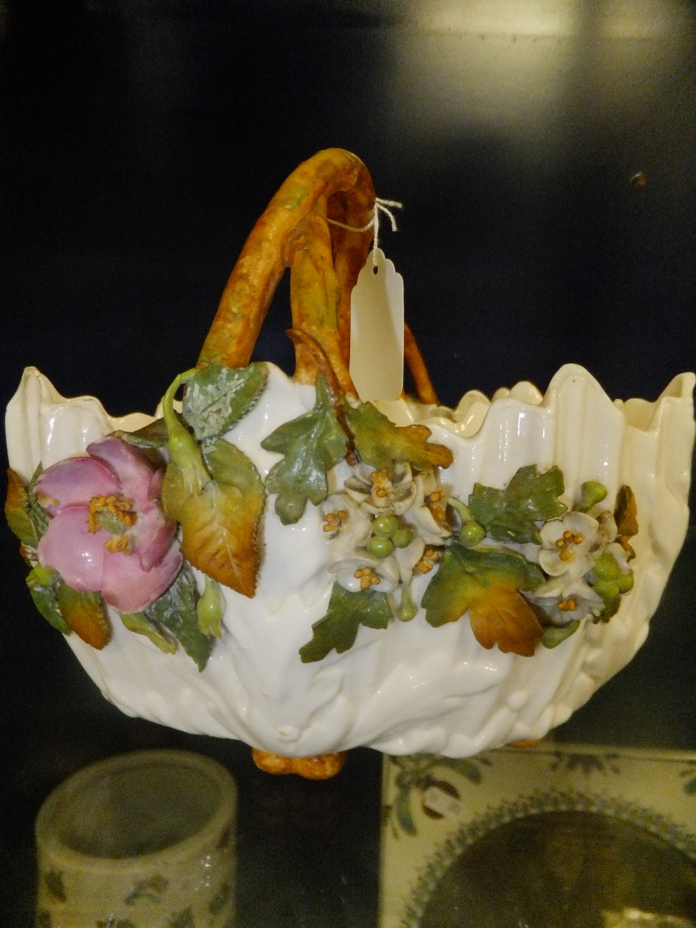 A pair of Victorian china baskets with raised flower decoration and cross-over handles