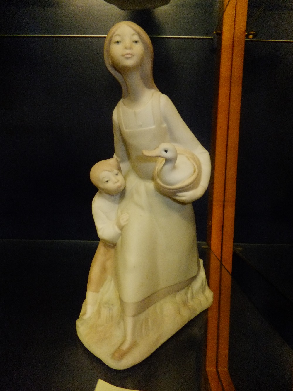 A Spanish porcelain figure of a female and child with a duck