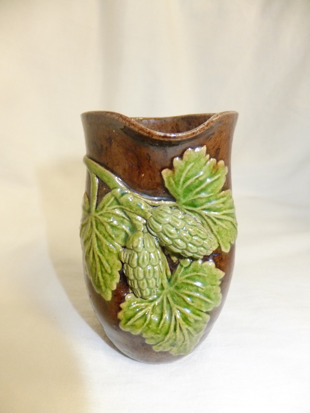 A circa 1920's Rye pottery vase having applied hop and vine decoration, 3.5"