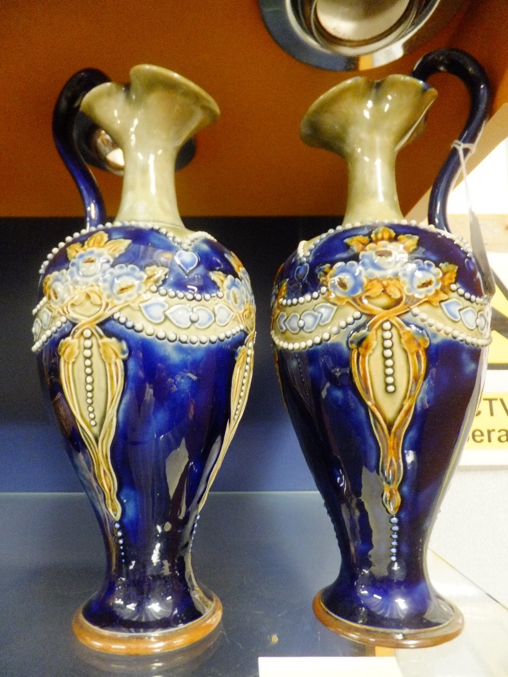 A pair of good quality C1910 Royal Doulton urn shaped jugs having floral decoration, signature to