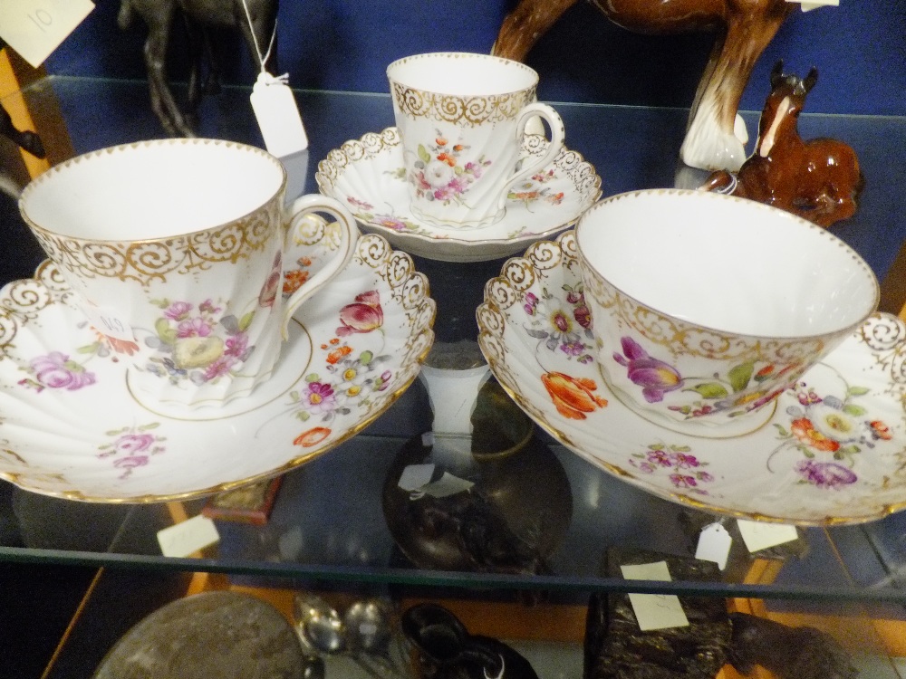 Three Dresden hand-painted cups and saucers with floral decoration