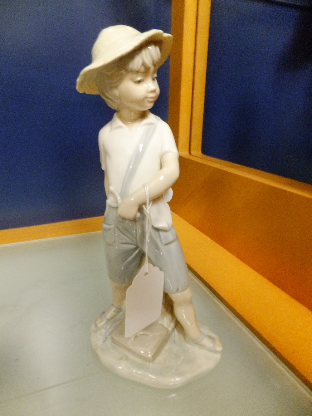 A Lladro figurine of a boy with a catapult