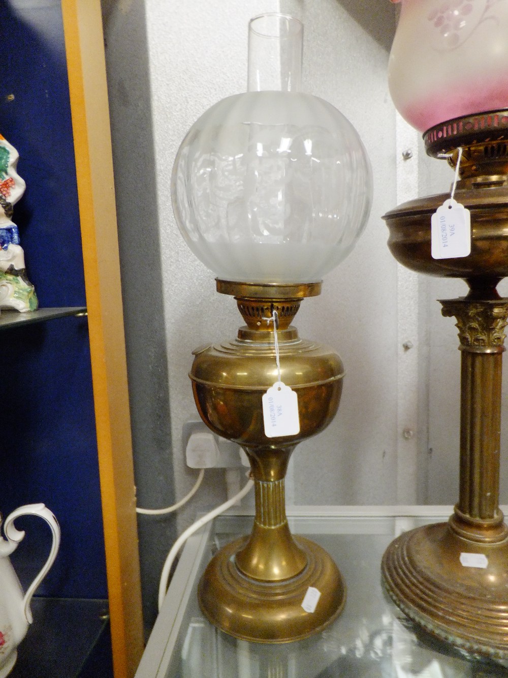 An early 20th C brass oil lamp with clear acid etched shade