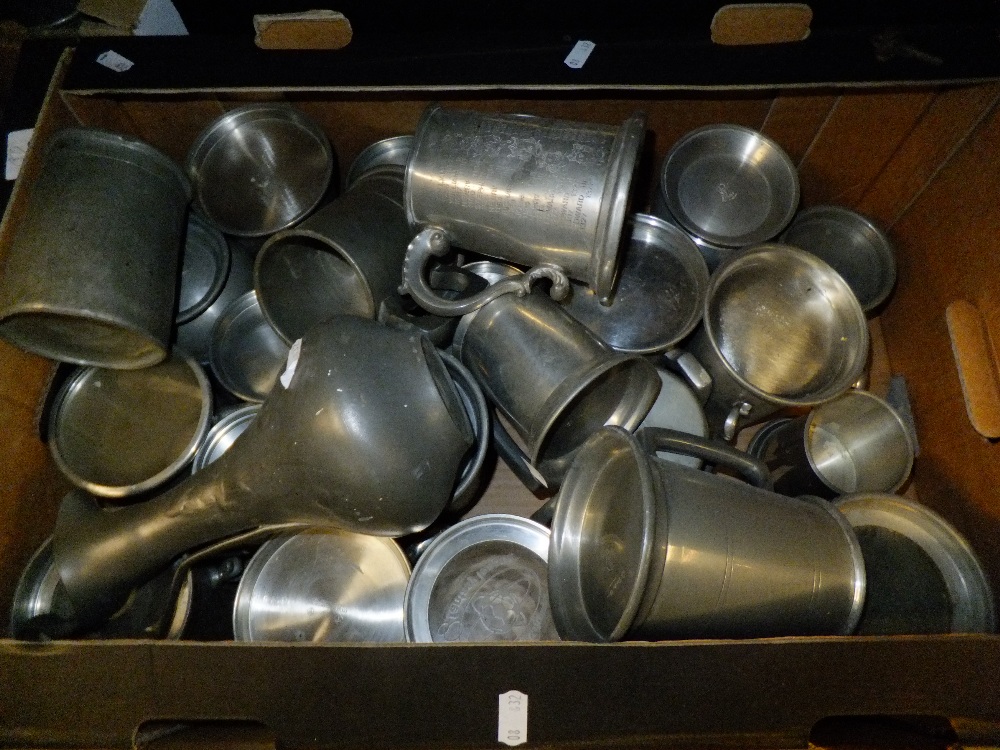 A large selection of pewter tankards and a jug