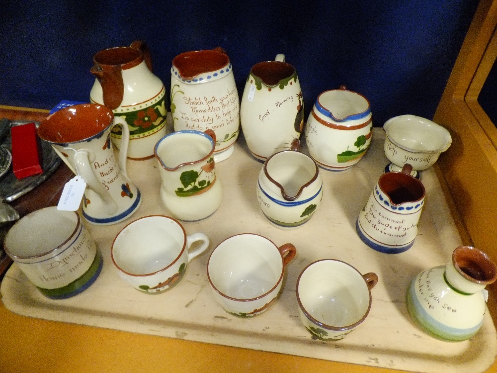 A large selection of Torquay Pottery motto-ware to include jugs, cups, slip jug etc