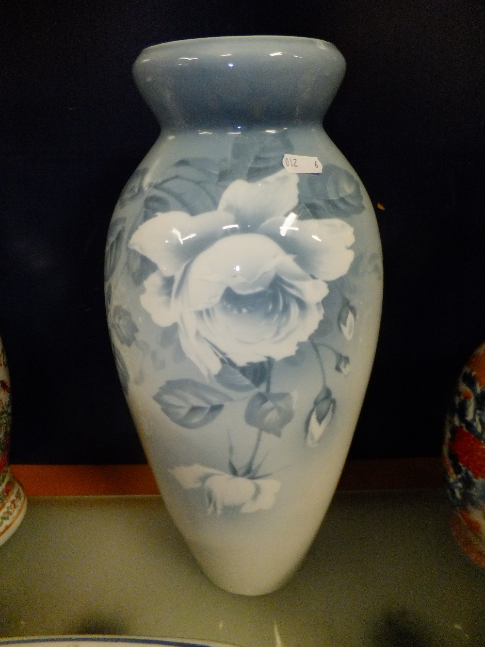 A large blue glazed continental hand-painted vase with floral decoration