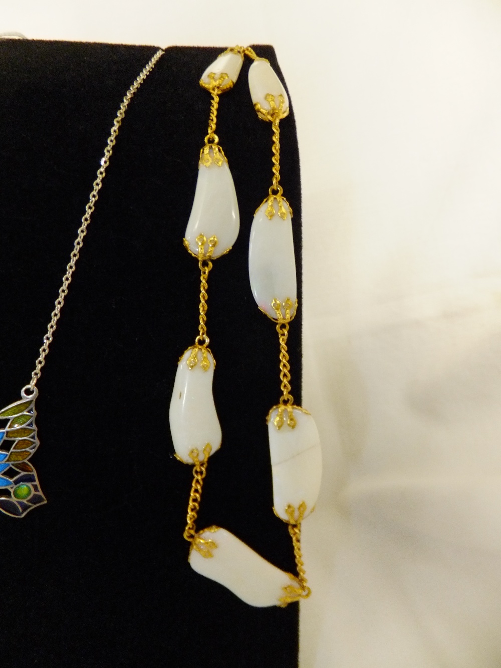 A polished opal necklace on a gilt chain