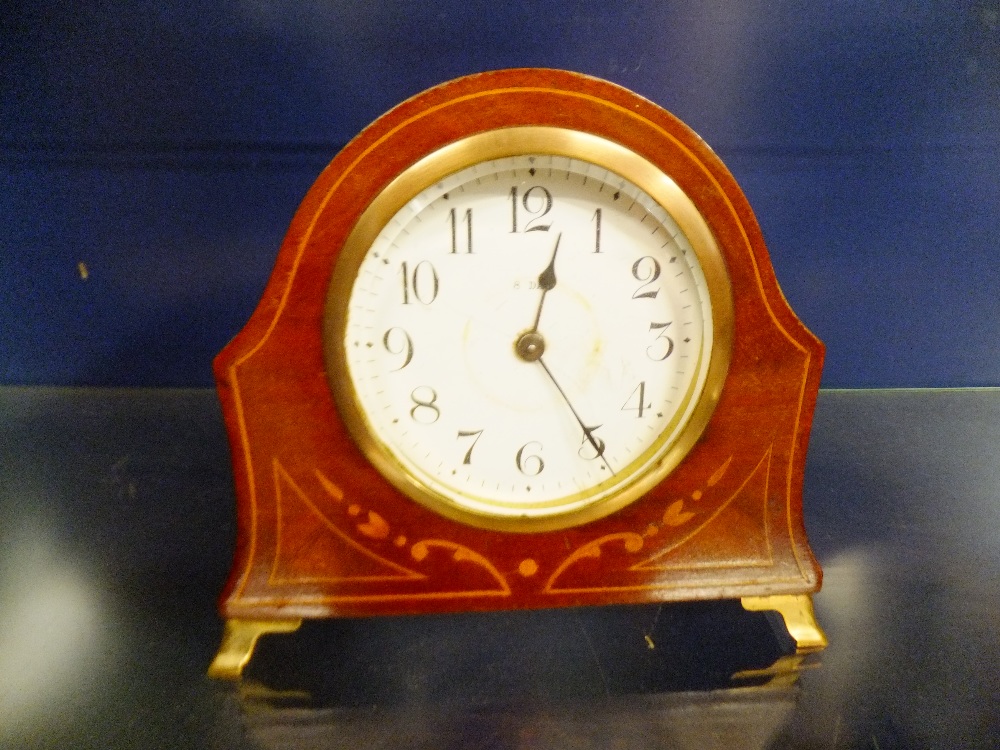 A 20th C mahogany inlaid time piece with eight day movement and resting on brass supports