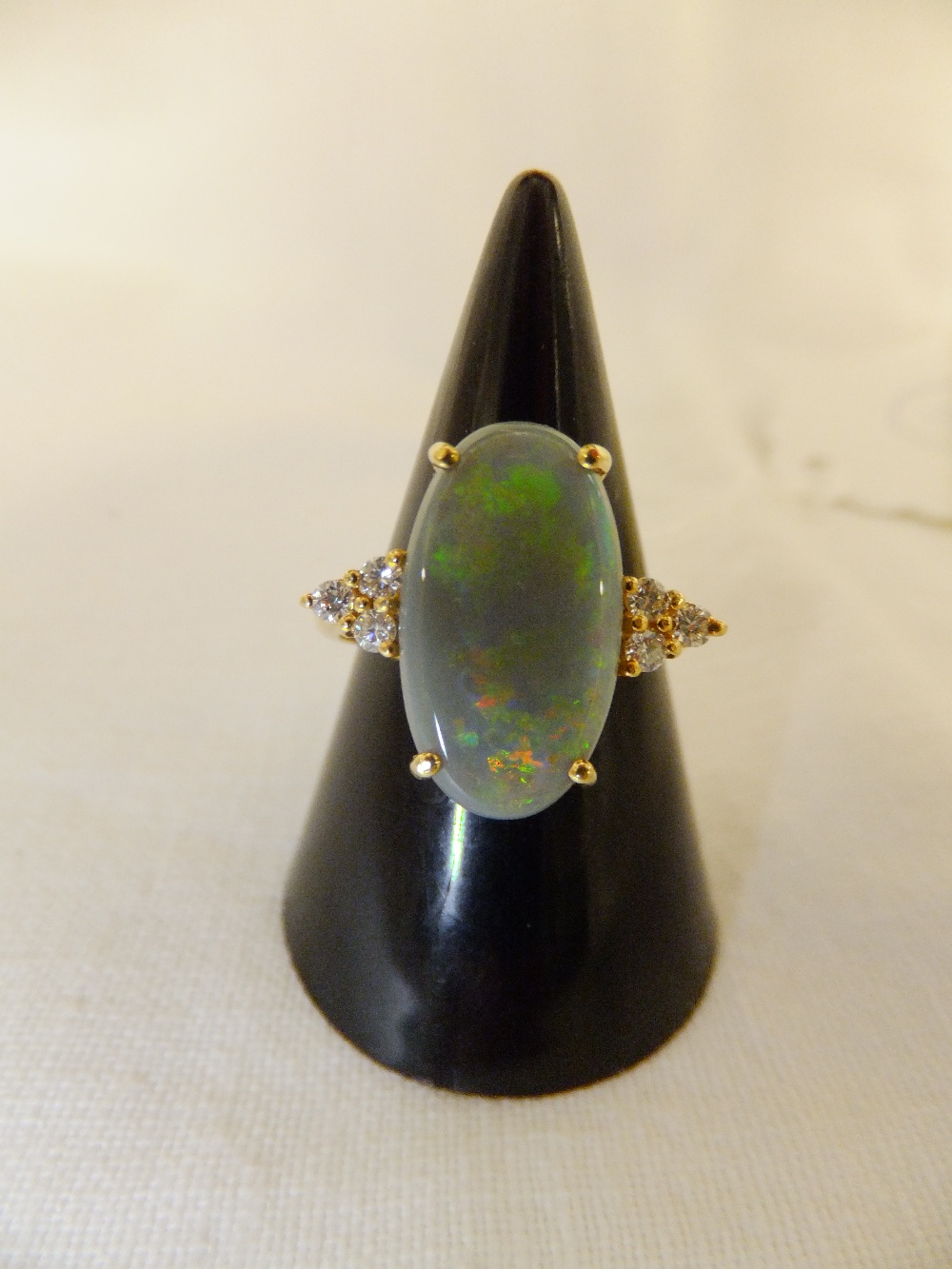 An 18ct gold ring having large central opal flanked by diamonds, size O