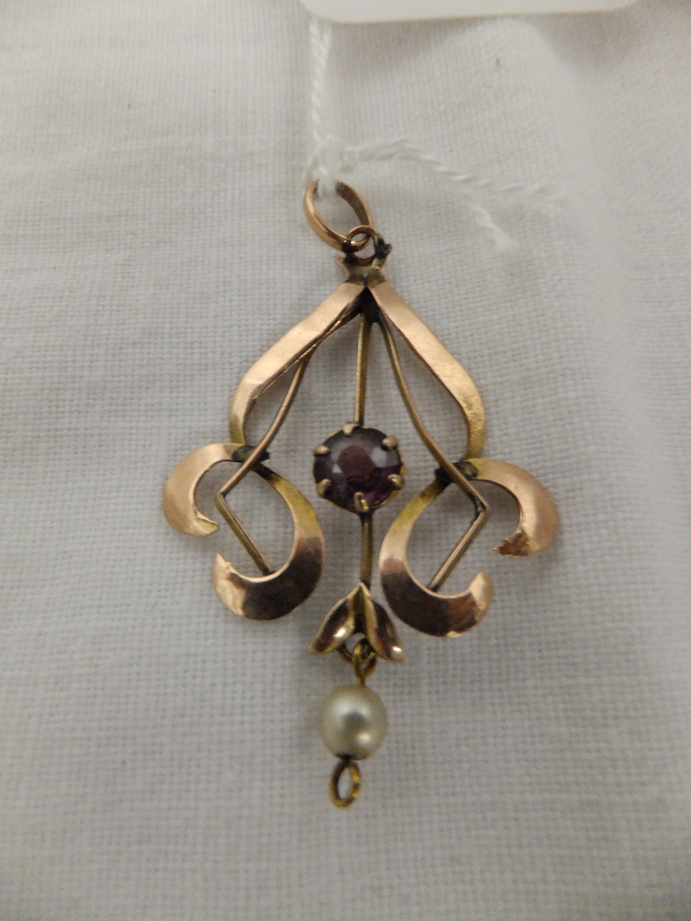 A 9ct gold pendant having central amethyst and pearl drop