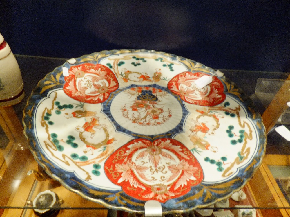 A Japanese Imari plate with boys and floral decoration