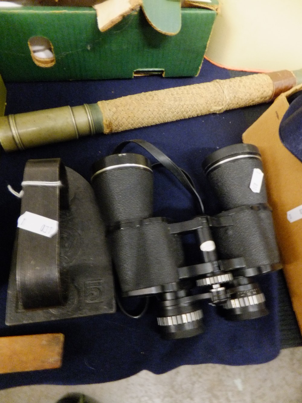 A pair of binoculars, a telescope and an iron paperweight