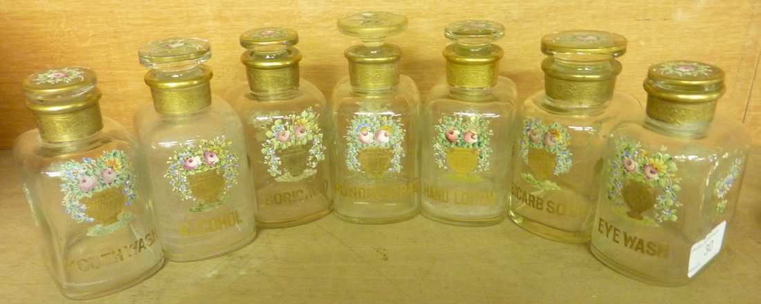 Set of seven continental glass chemist jars with painted floral and gilt detail and gilt lettering