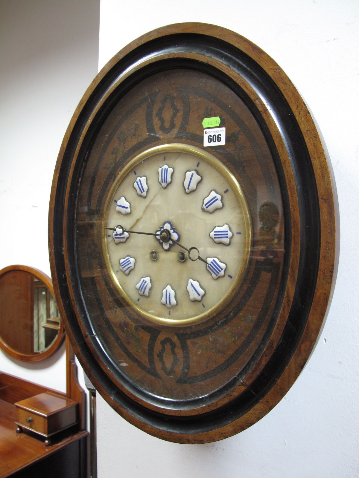 A XIX Century Walnut Ebonised Oval Shaped Wall Clock, with enamel Roman numerals, on a marble back