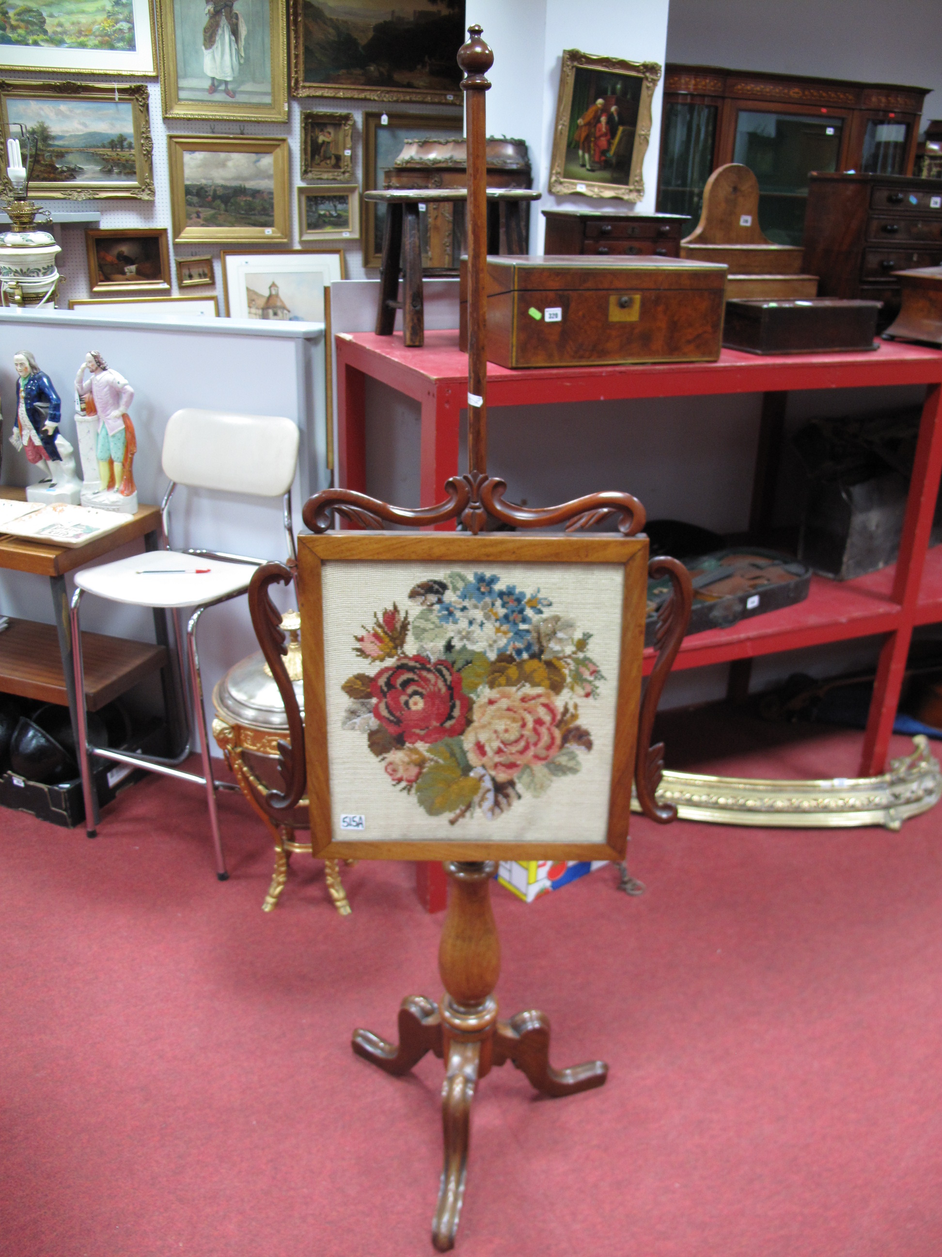 An Early Victorian Rosewood Polescreen, the glazed rectangular banner with ornamental carved side