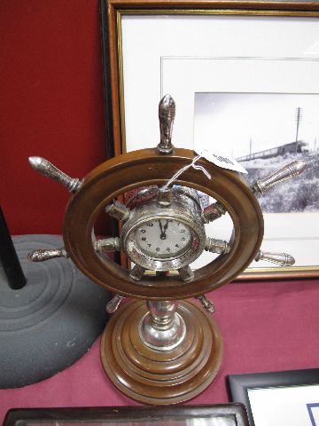 An Early XX Century Brown Bakelite and Plated Clock, formed as a ships wheel, on baluster pillar