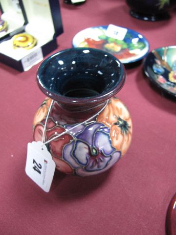 A Moorcroft Pottery Vase, of squat baluster form, decorated with pansies on a dark red ground,