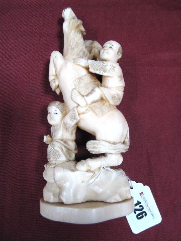 An Early XX Century Japanese One Piece Ivory Tusk Okimono, as a man mounted on a rearing horse, a