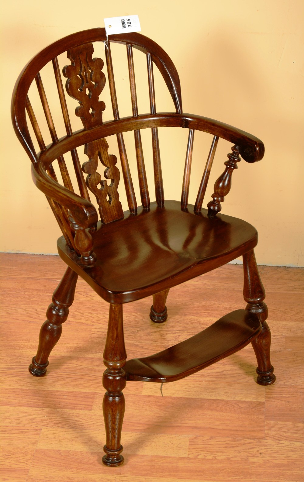 A child's Windsor chair, with hoop back and arms, with pierced central splat, solid seat, on splayed