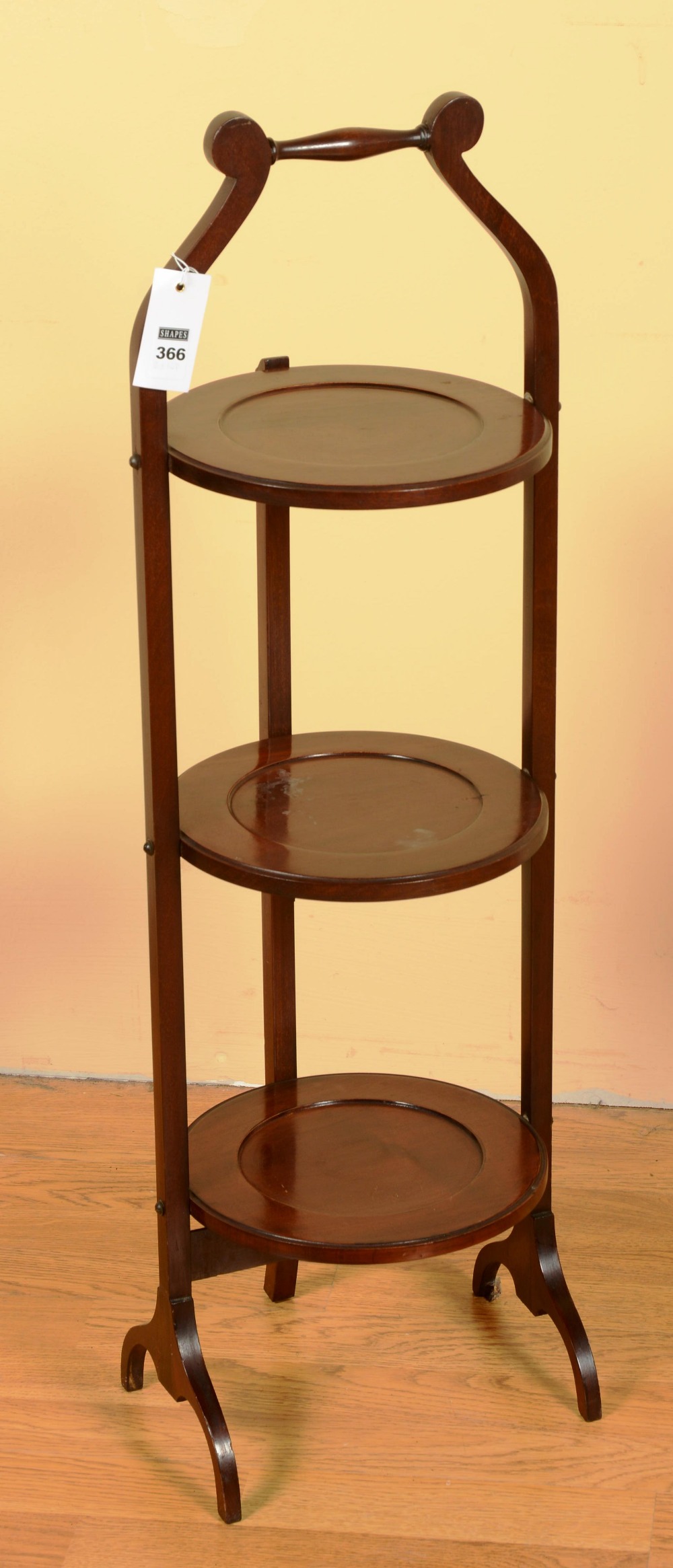 A three tier mahogany cake stand, each tier of circular form on square uprights, 88cm high